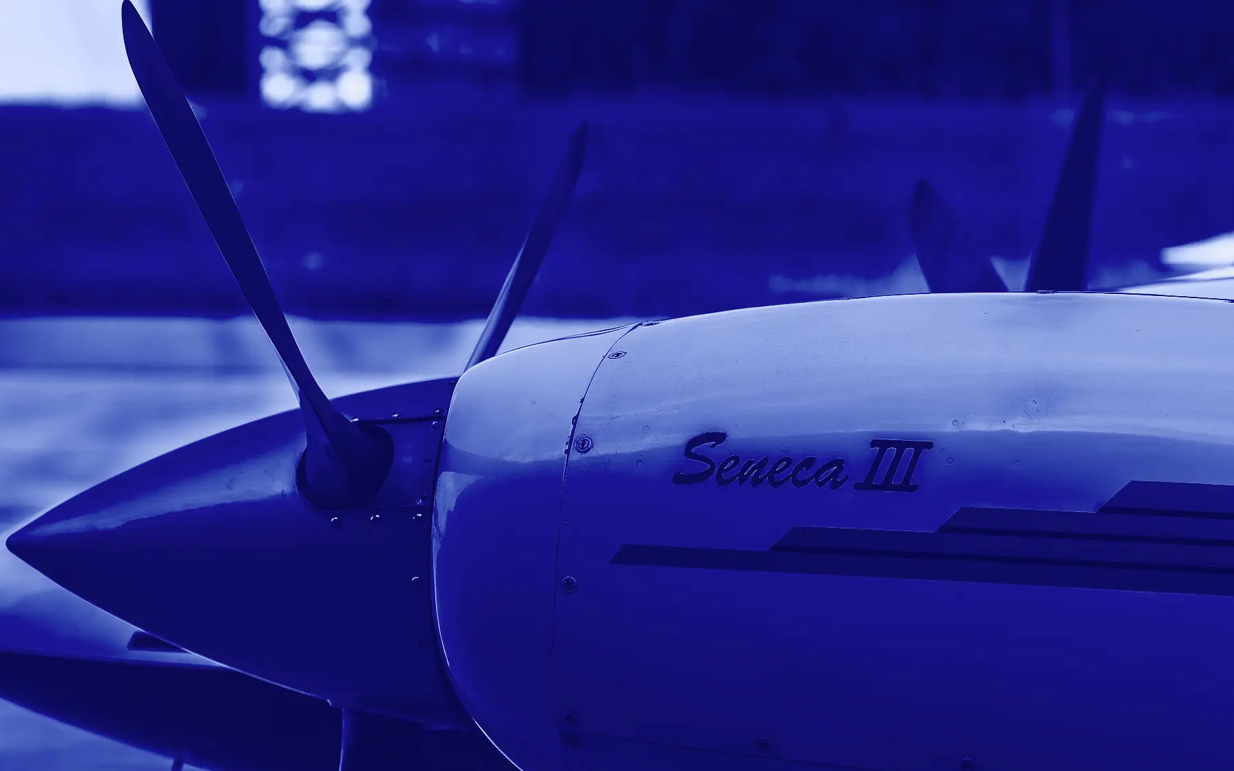 Capô do motor de um Piper Seneca III com a hélice, em tons de azul